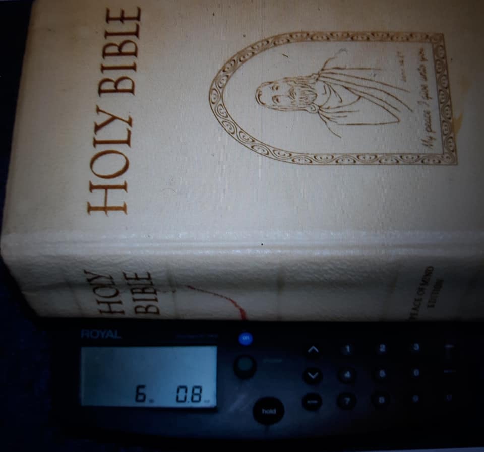 The family Bible placed on a scale reading 6.08 lbs — the same Bible witnessed lifting off the bed and slamming shut on its own